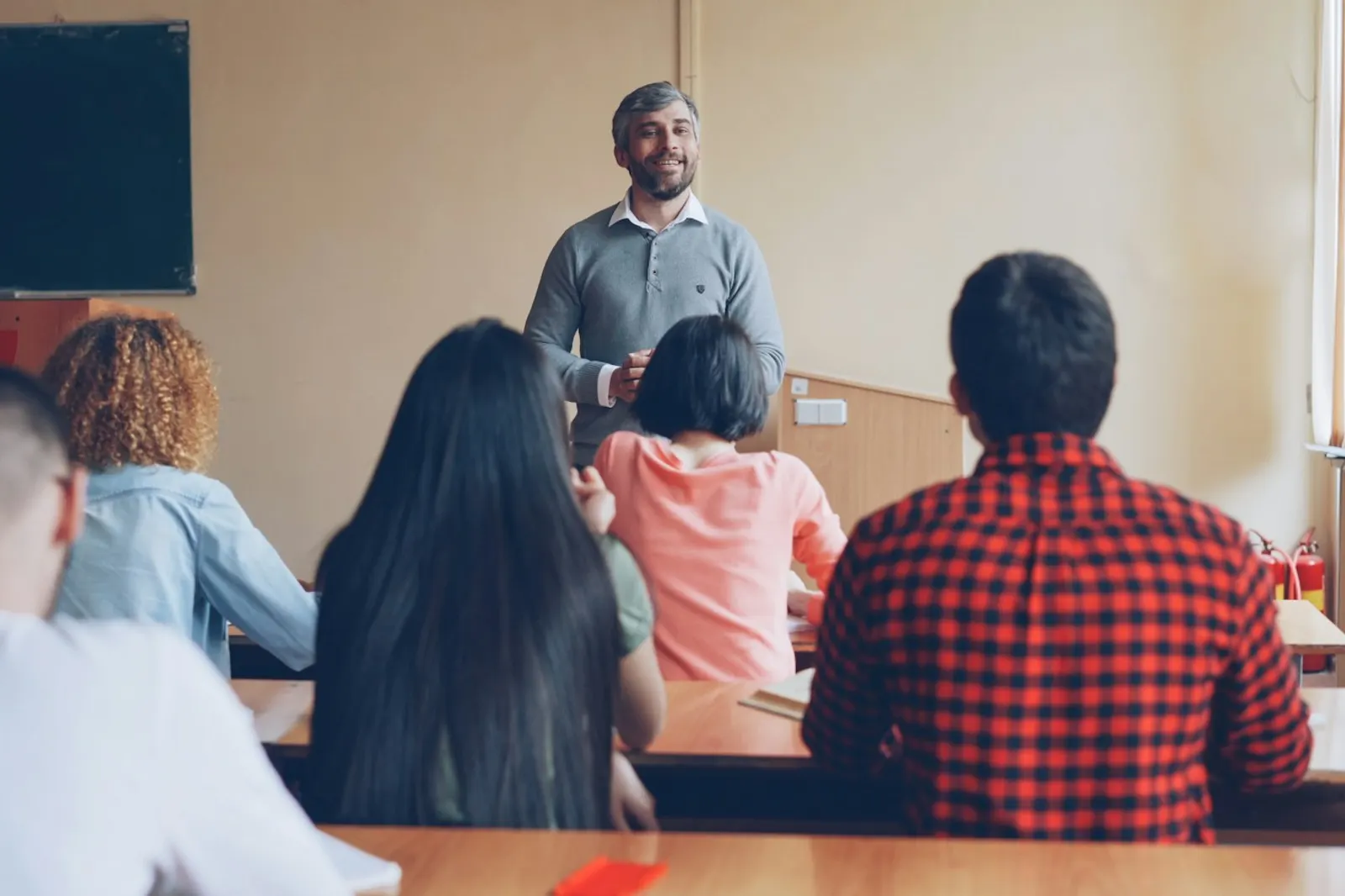 Un profesor da clase a un grupo de alumnos en un aula